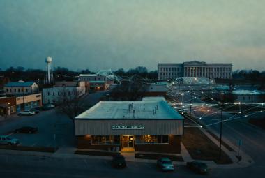 A small town clinic is connected via data flows to a federal government style building in the distance